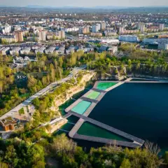 Widok na Zakrzówek Kraków kąpielisko z drewnianymi pomostami i basenami w otoczeniu zieleni i zabudowy miejskiej.