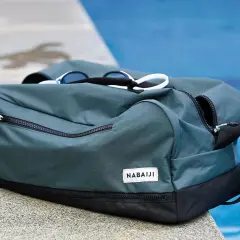 Zielona torba na basen dla dziecka z goglami na wierzchu, gotowa na wodne przygody.
