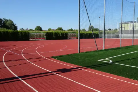 Bieruński ośrodek sportu i rekreacji: bieżnia, boisko ze sztuczną trawą, bramki i zadaszone ławki.