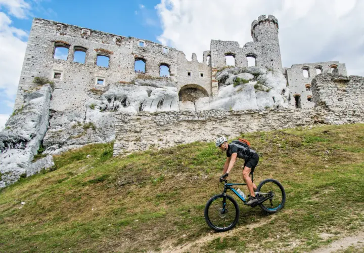 Rowerzysta na tle ruin zamku. Odkryj malownicze trasy rowerowe Śląsk i poczuj ducha historii.