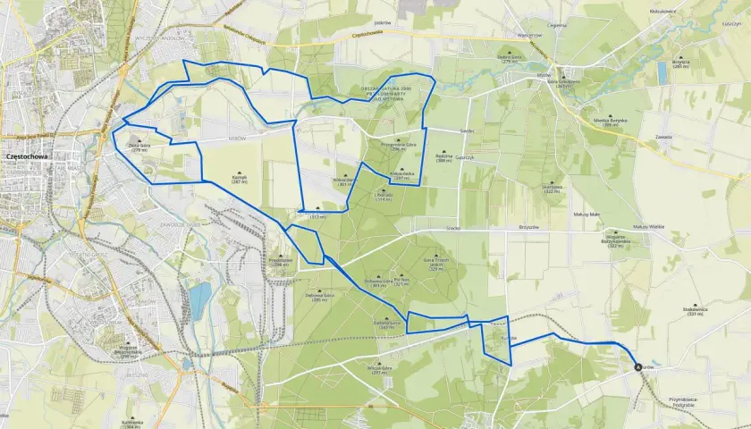 Mapa z zaznaczonymi trasami rowerowymi wokół Olsztyna. Szlak prowadzi przez tereny zielone, w pobliżu wzgórz i lasów.