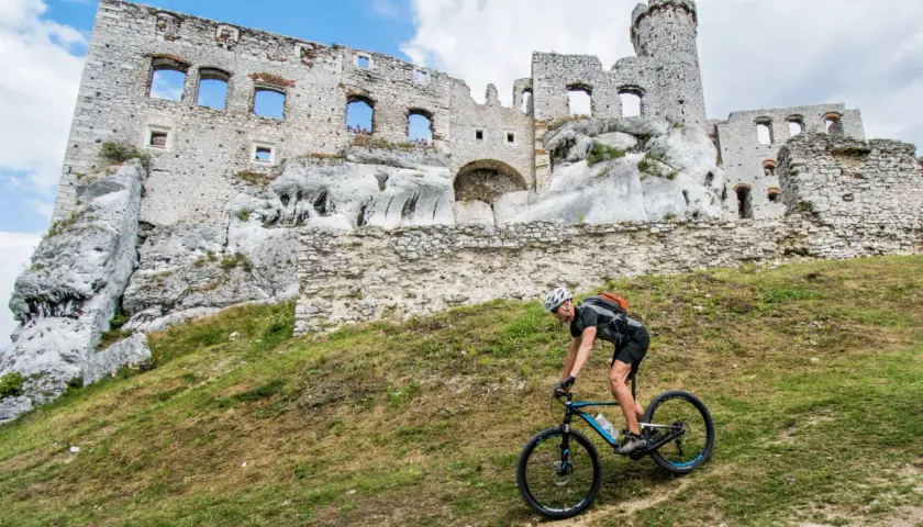 Rowerzysta na tle ruin zamku. Odkryj malownicze trasy rowerowe Śląsk i poczuj ducha historii.
