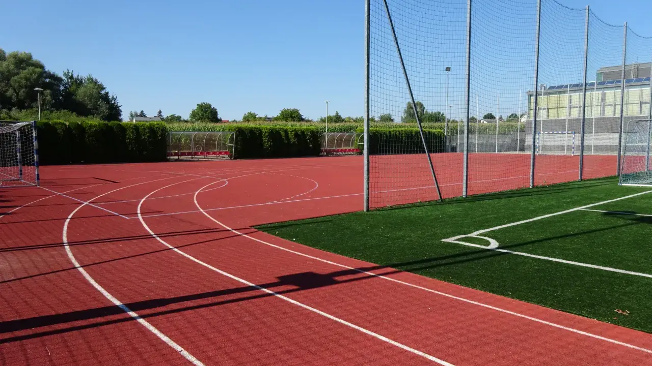 Bieruński ośrodek sportu i rekreacji: bieżnia, boisko ze sztuczną trawą, bramki i zadaszone ławki.