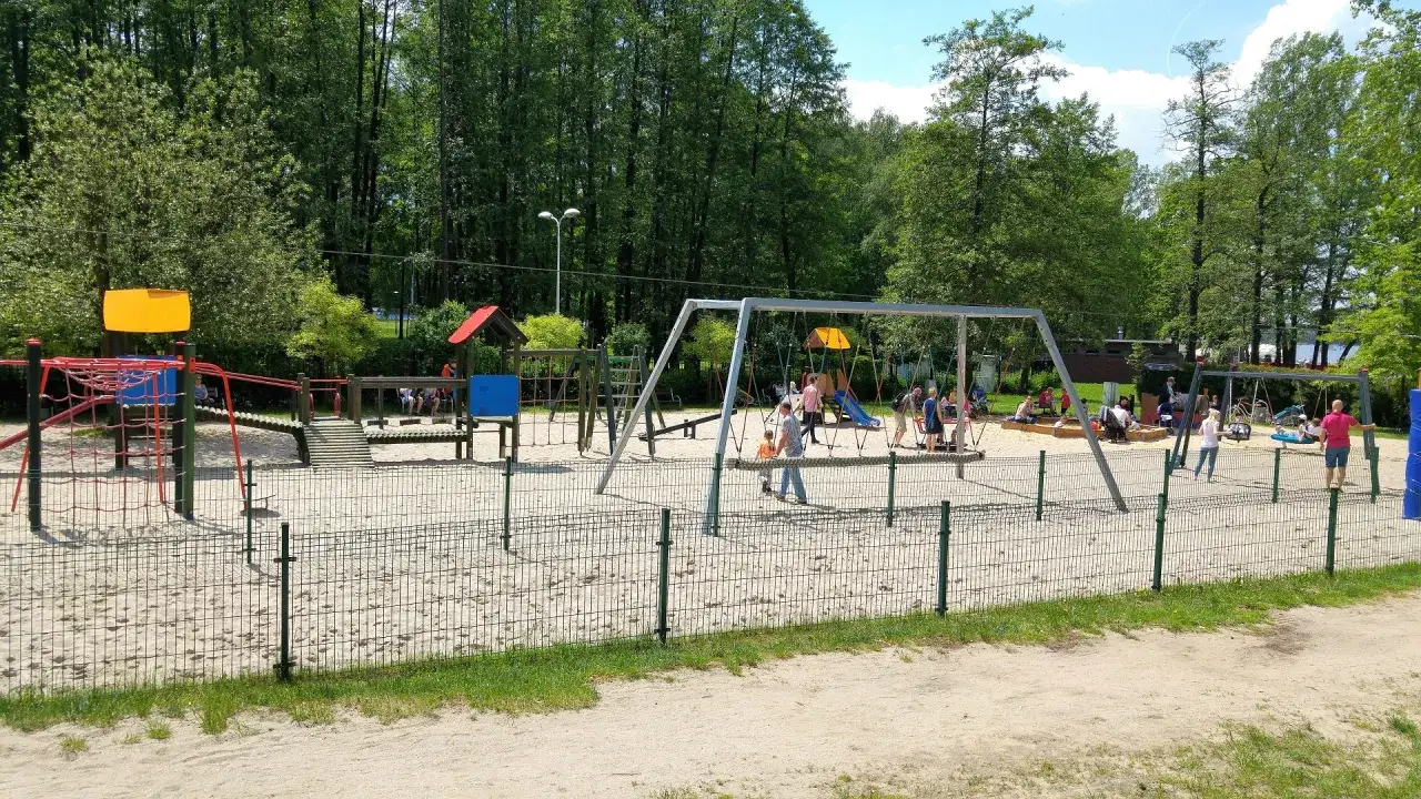 Plac zabaw na Paprocanach w Tychach, z huśtawkami i zjeżdżalnią, zachęca do aktywnego spędzania czasu na świeżym powietrzu.