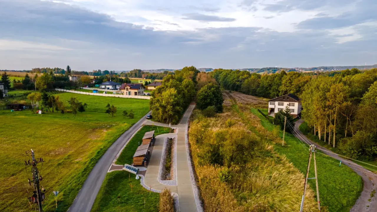 Malowniczy krajobraz z domami, lasem i nowym żelaznym szlakiem rowerowym Godów.