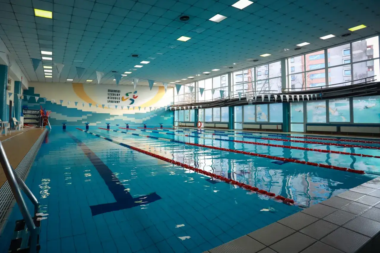 Krakowski Szkolny Ośrodek Sportowy - międzyszkolny basen pływacki z torami, drabinkami i oknami z widokiem na miasto.